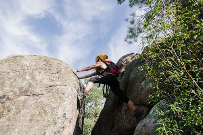 Explorer climbing rock in forest at la pedriza, madrid, spain