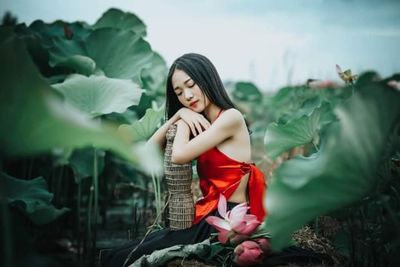 Portrait of woman standing against plants