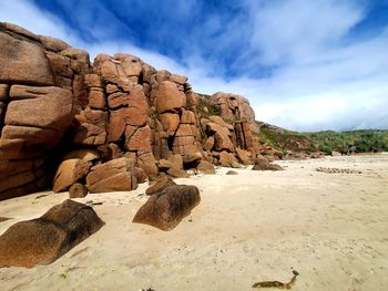 Rock formation on beach against sky