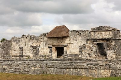 Low angle view of old ruin building against cloudy sky