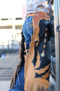 Midsection of person with umbrella standing in city