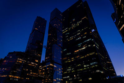 Low angle view of illuminated buildings against sky at dusk