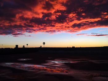 Scenic view of silhouette beach against sky during sunset