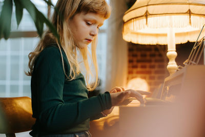 Side view of girl playing a piano