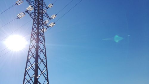 Low angle view of power lines against blue sky