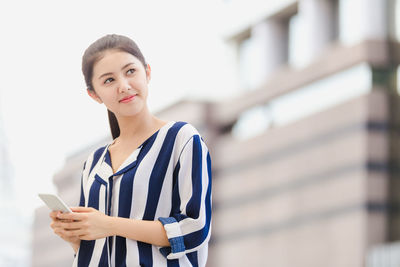 Portrait of a young woman using mobile phone