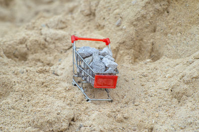 Selective focus on shopping trolley carries the crushed stones on the pile of sand at the site