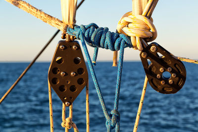 Close-up of rope tied to bollard against sky