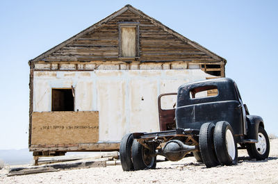 Abandoned vintage car on land against sky