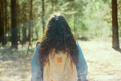 Rear view of backpacker hiking in forest