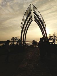 People on bridge at sunset