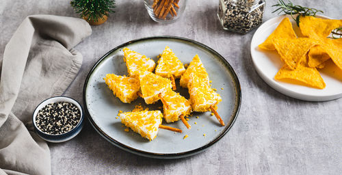 Fake christmas trees made from triangle cheese in nacho crumbles on a plate web banner