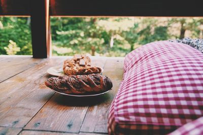 Close-up of cookies served in plate at wooden balcony