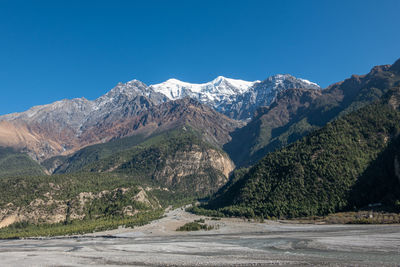 Scenic view of mountains against clear blue sky
