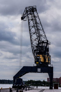 Low angle view of crane at harbor
