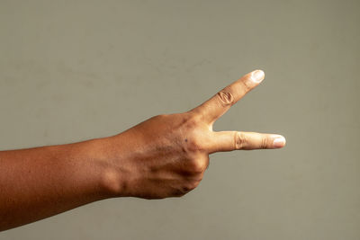 Close-up of hand against wall