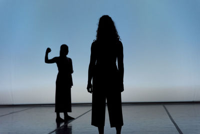 Silhouette women standing against clear sky