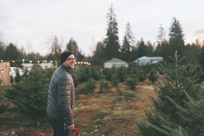 Side view of mature man standing on landscape against sky during winter