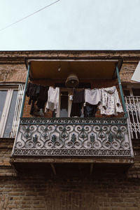 Low angle view of clothes drying on building against sky