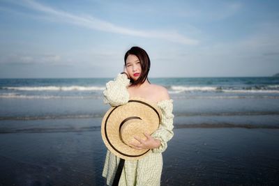 Portrait of young woman standing on beach
