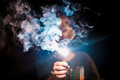 Close-up of boy playing the sparkles in the dark