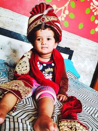 Low angle view of cute girl sitting on bed at home