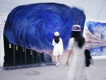 Rear view of woman holding umbrella