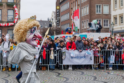 People on street against buildings in city