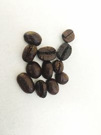 High angle view of coffee beans against white background