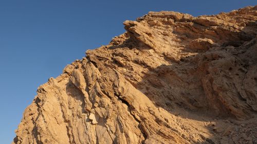 Low angle view of rock formation against clear sky