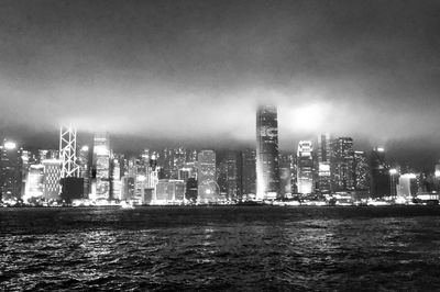 Illuminated buildings in city against sky at night