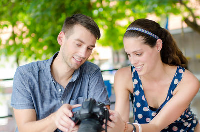 Couple looking at camera while sitting at park