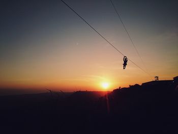 Silhouette of one woman on zip line