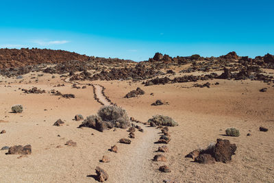 Scenic view of rock formations in desert against blue sky