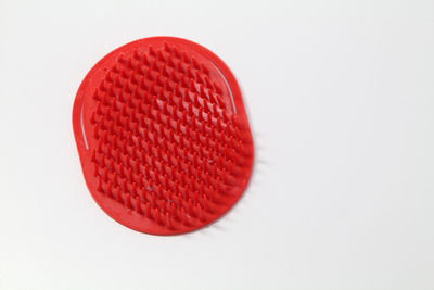 Directly above shot of red comb on gray background