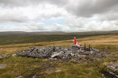 Scenic view of canadian flag on landscape against sky. wreckage of wellington bomber mf509