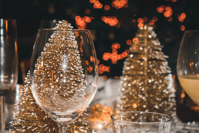 Close-up of wine glass against illuminated christmas lights