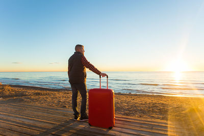 Full length of man standing on beach during sunset