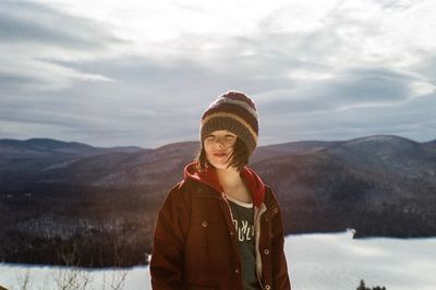 Portrait of girl standing in snow against sky