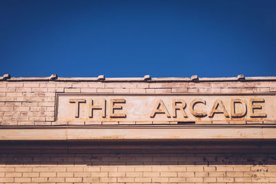 Low angle view of the arcade sign on building against clear sky