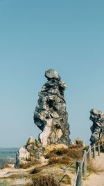 Low angle view of rock formation against clear blue sky