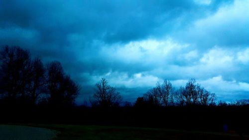 Silhouette of trees against cloudy sky