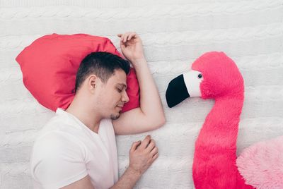 Man with toy sleeping on bed