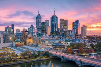 Aerial view of buildings against cloudy sky during sunset