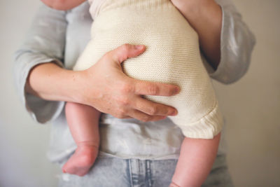 Mother holds her baby in eco-friendly diaper, eco-friendly swaddling systems 