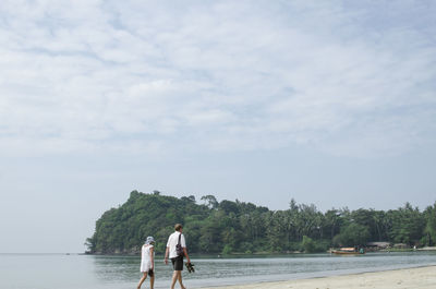 Couple walking at shore of beach