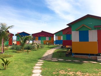 Beach huts by buildings against sky