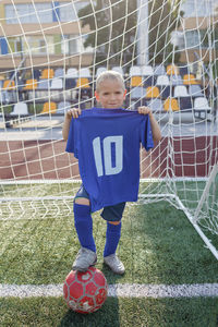 Full length of a boy ball on soccer field