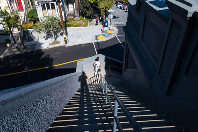 High angle view of woman standing on steps in city