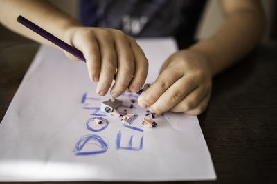 The child's hands with a pencil and sharpener over the paper with the inscription, do not enter